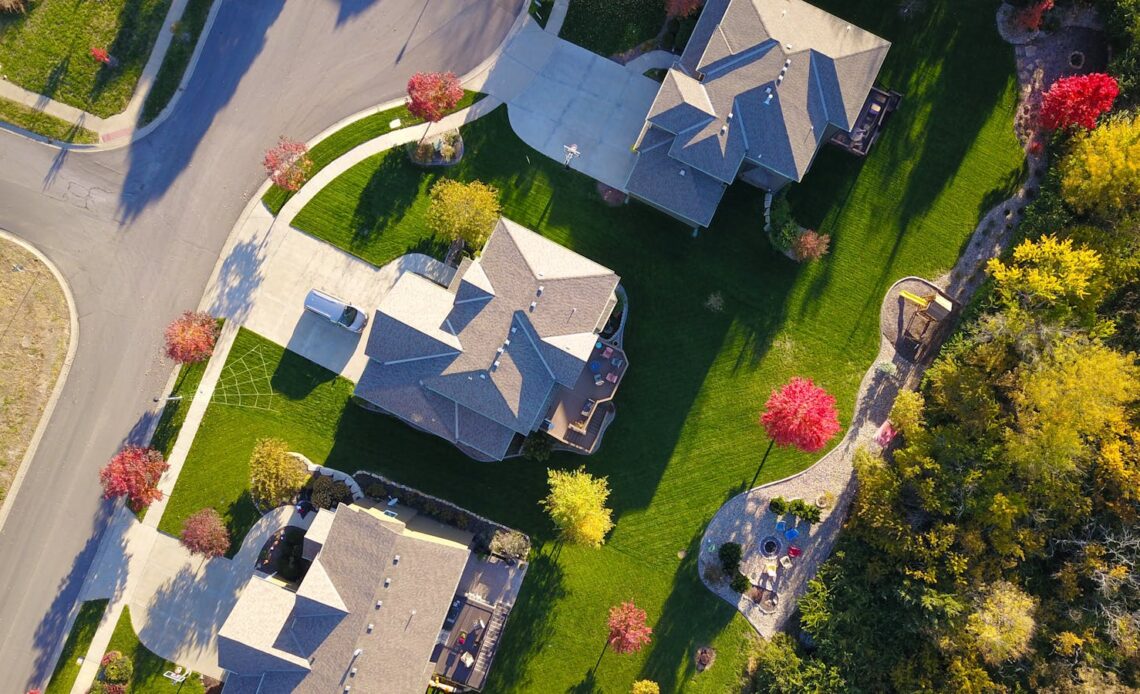 A picturesque aerial view showcasing suburban homes with vibrant gardens and tree-lined streets.