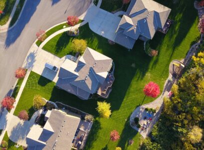 A picturesque aerial view showcasing suburban homes with vibrant gardens and tree-lined streets.